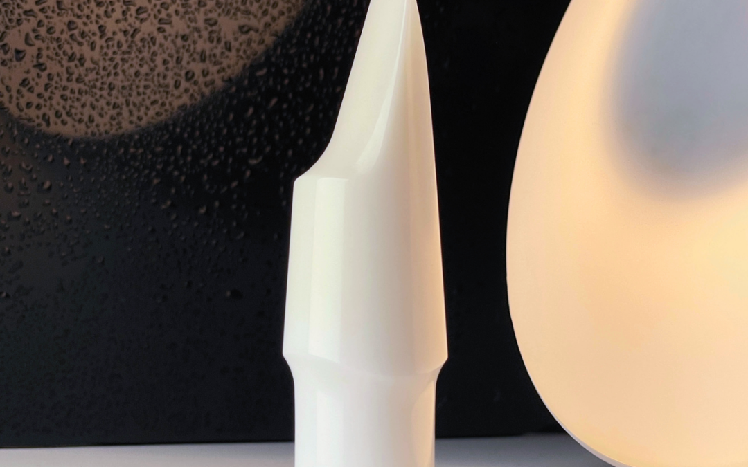 Forme blanche incurvée en céramique technique posée sur un fond sombre texturé en gros plan